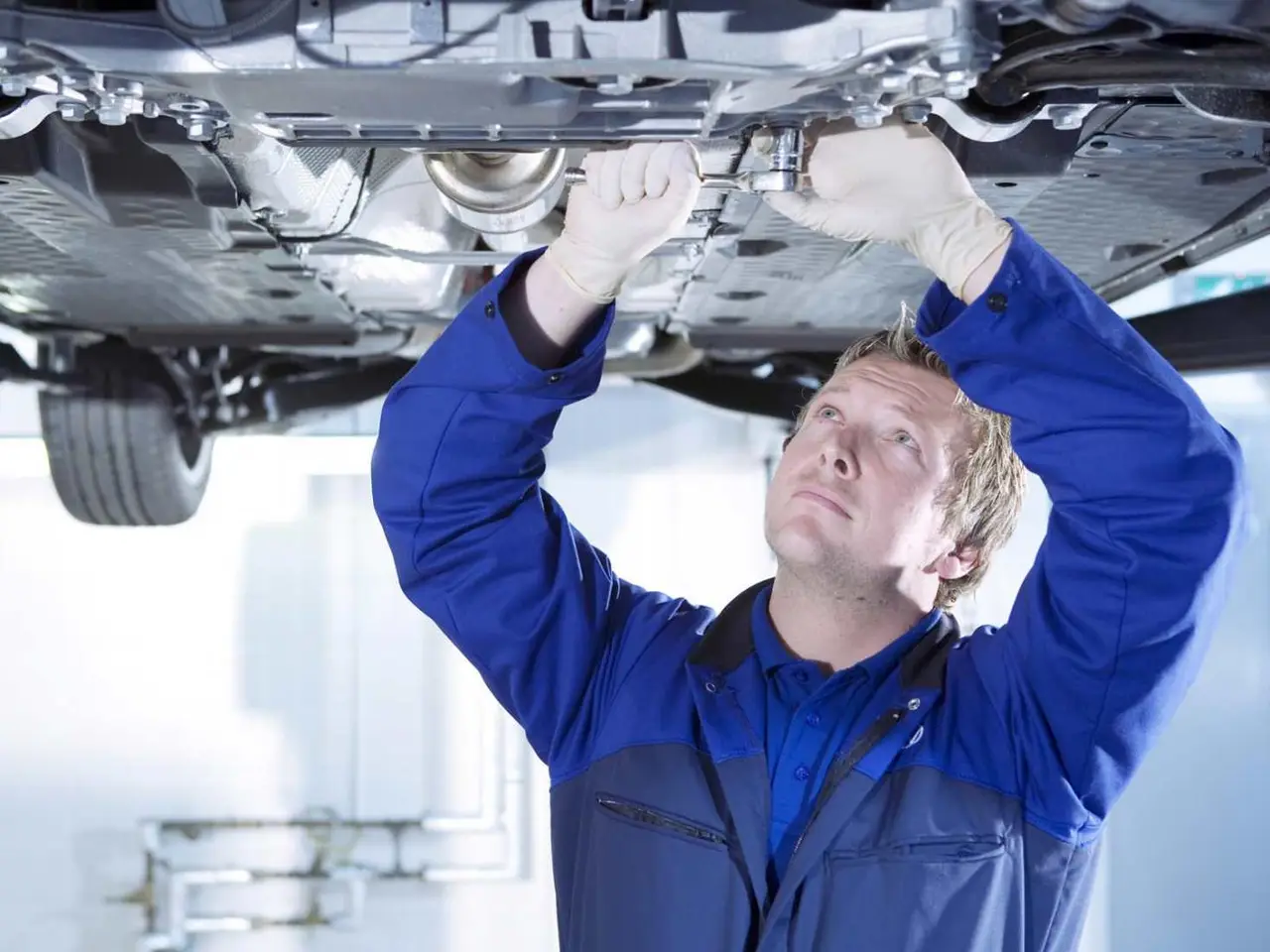Qualified MOT tester inspecting the underside of a car RPM Motor Services Seaton
